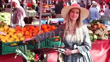金发女孩骑着自行车站在市场上，微笑着